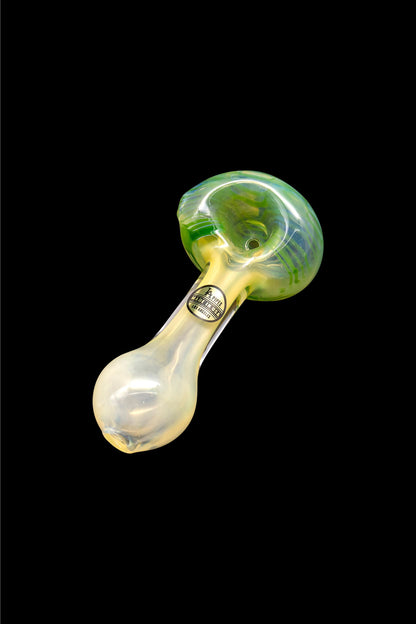 Glass pipe with iridescent yellow and green swirls, against a black background.