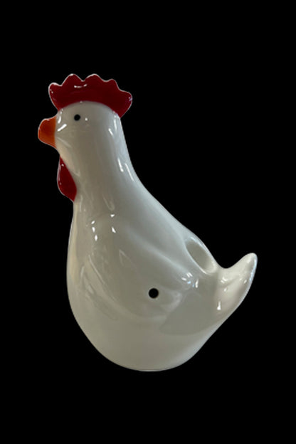 White ceramic chicken-shaped water pipe with red comb, isolated on black.