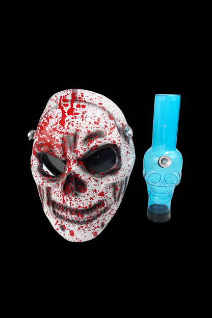 A bloody horror mask alongside a blue glass water pipe.