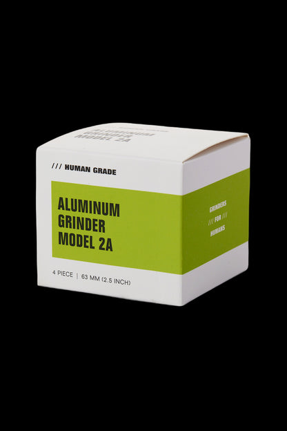 Close-up of a green and yellow aluminum cannabis grinder box labeled "Model 2A" and "Human Grade".