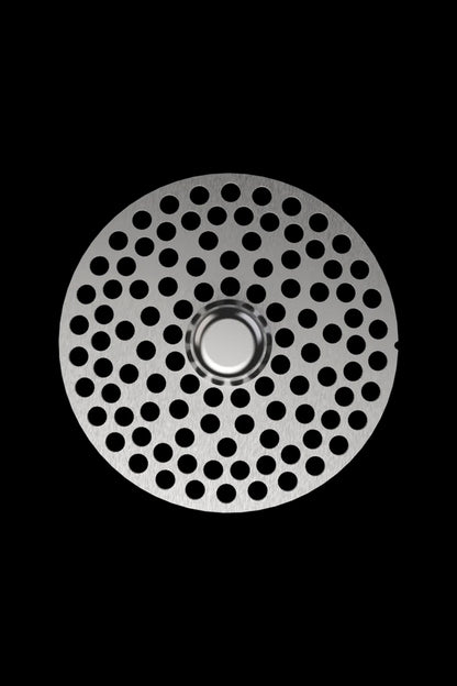 Metal grinder plate with numerous small holes, isolated on black.