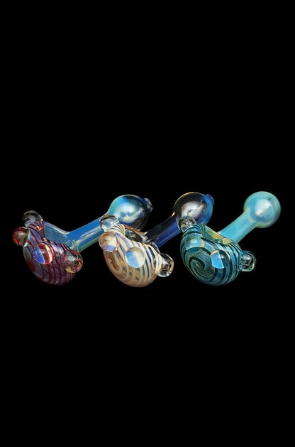 Hand-blown glass pipes in vibrant red, blue, and gold hues against a black background.