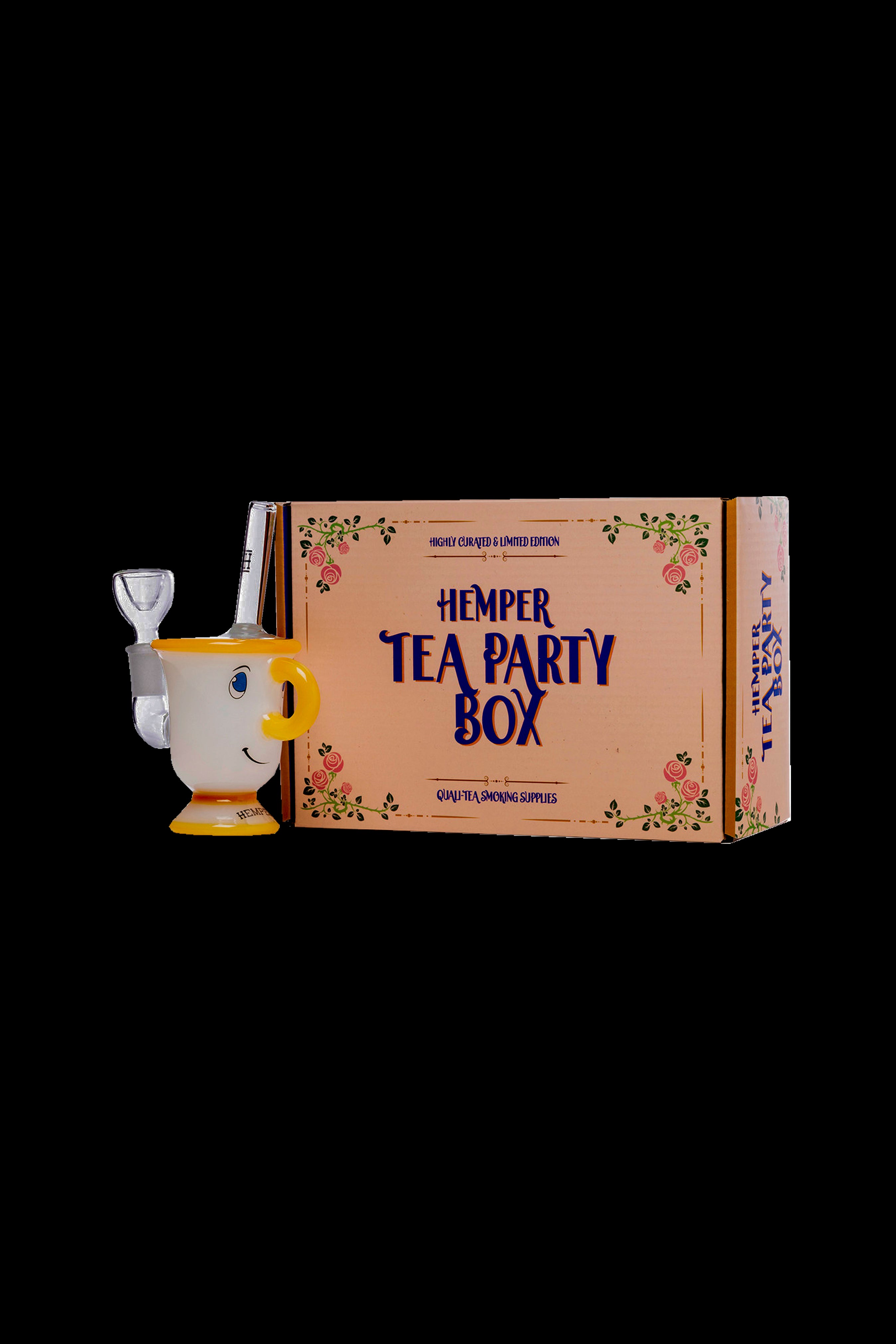 A wooden cannabis water pipe displayed alongside a decorated box labeled “Hemper Tea Party Box: Quality Smoking Supplies.”