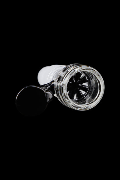 Glass cannabis bowl with intricate internal diffusion slits, isolated on a black background.