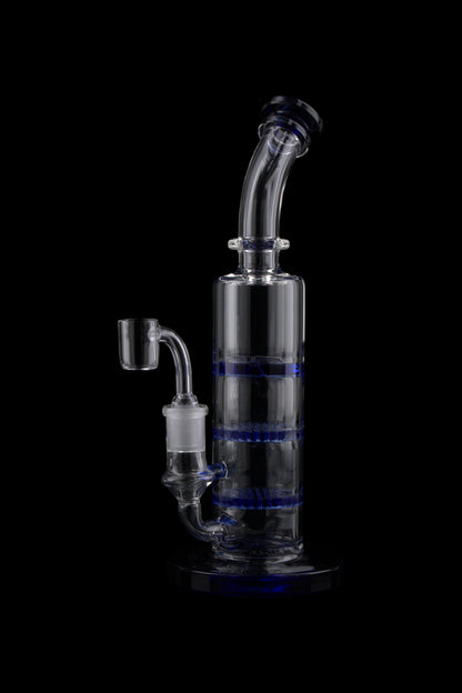 Studio-lit, side view of the Triple Honeycomb Dab Rig showing its clear glass neck, blue honeycomb percs, and angled mouthpiece against a black background
