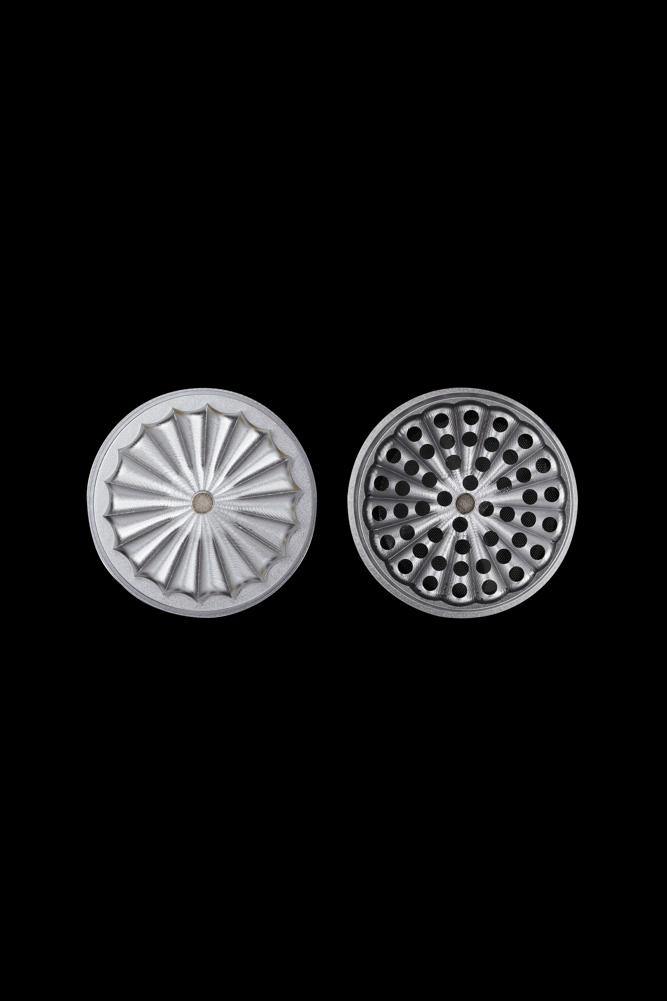 Metal grinder plates with radial and hole patterns, isolated on a black background.