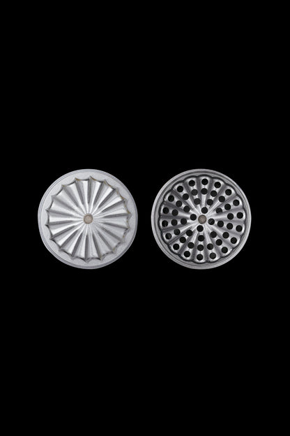 Metal grinder plates with radial and hole patterns, isolated on a black background.