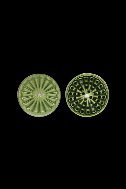 Two green, patterned cannabis smoking filters displayed against a black background.