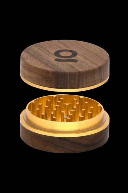 Wooden cannabis grinder with gold interior, lid slightly raised.