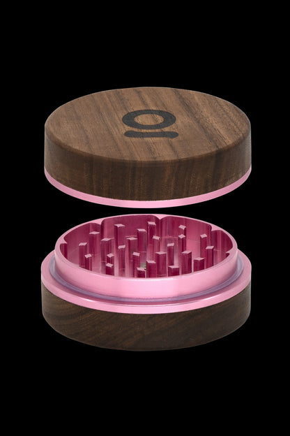 Wooden cannabis grinder with pink metal interior, shown open.