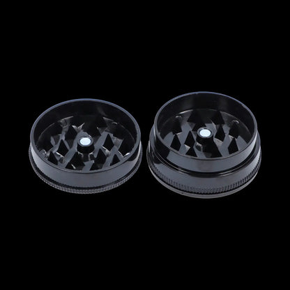 Top-down view of the open Black Skull Mini Travel Grinder showing both black interlocking halves with diamond-shaped teeth.