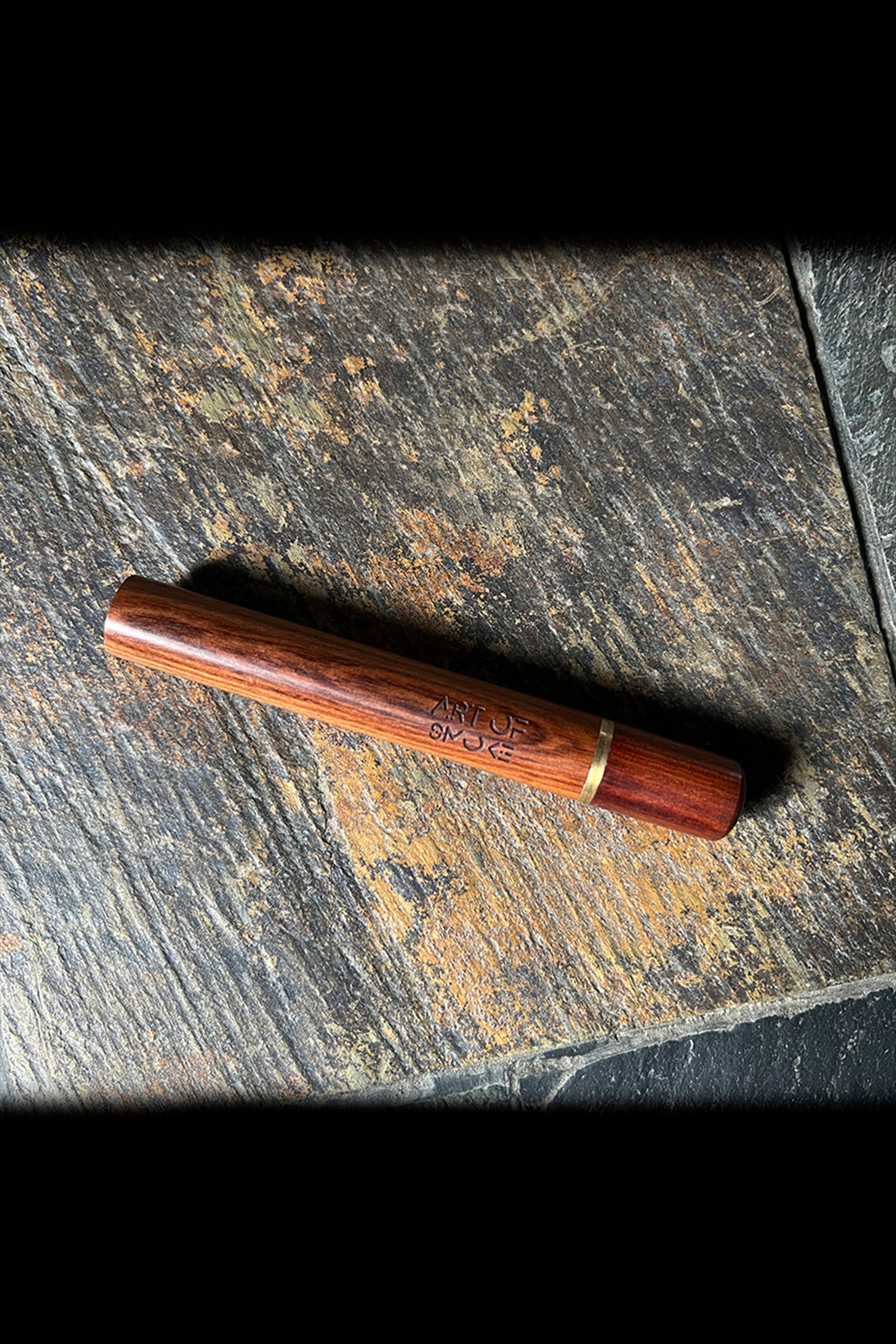 Wooden dugout with “Art of Smoke” engraved on the side, resting on dark slate.