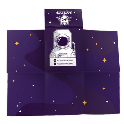 Navy blue cannabis accessory wrap featuring a white astronaut illustration and “Kozo Grinders” branding with scattered star graphics.