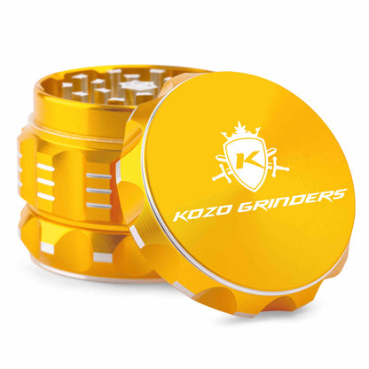 Yellow metal cannabis grinder with “Kozo Grinders” logo, open to reveal ground herb.
