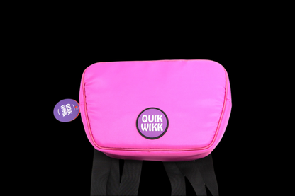Top-down view of a bright pink Quik Wikk Fanny Pack with a round Quik Wikk logo on the front and black straps visible below.