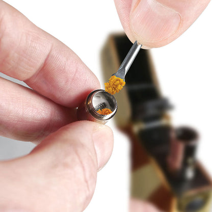 Close-up top-down view of a hand holding the RYOT® 3 Pack Of Extra Coils For 710 Wax Tank - New coil while a small metal dab tool deposits golden concentrate into its threaded chamber.