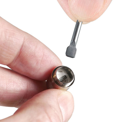 Close-up of hands holding a small metal coil and tool, showing the threaded interior spring of the RYOT® 3 Pack Of Extra Coils For 710 Wax Tank - New