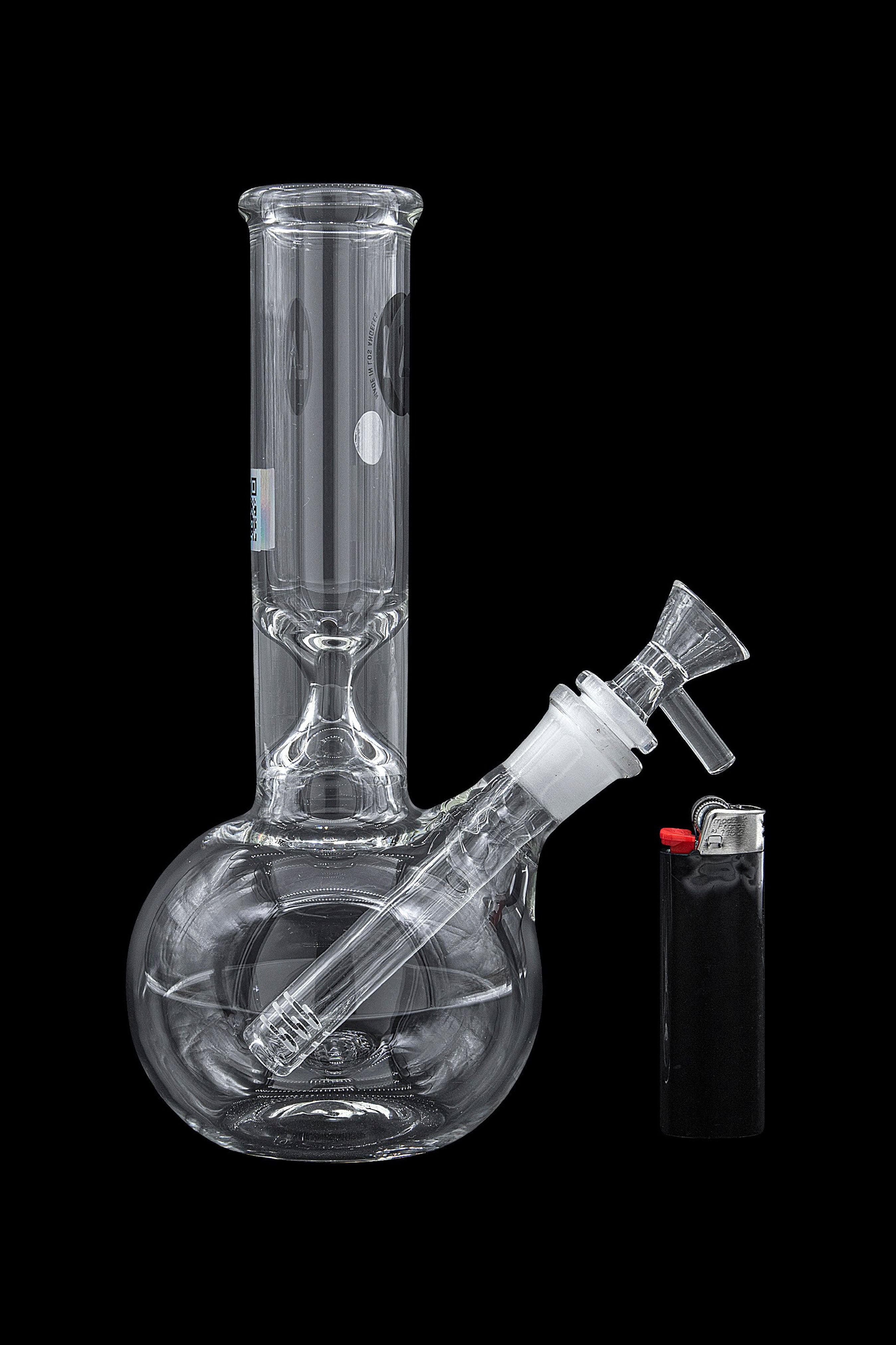 Glass water pipe (bong) and lighter on a black background.