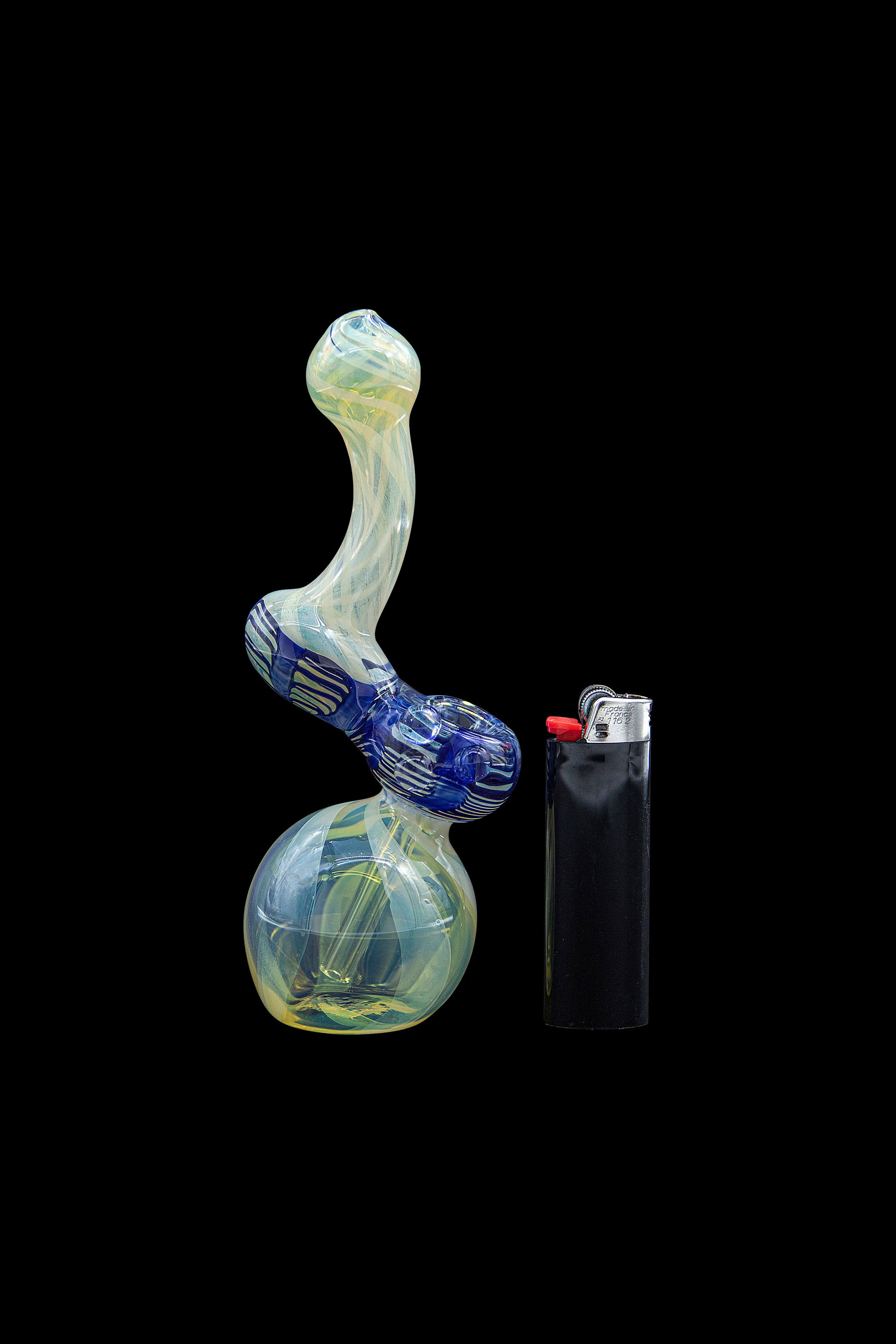 A colorful glass water pipe (bubbler) stands beside a lighter on a black background.