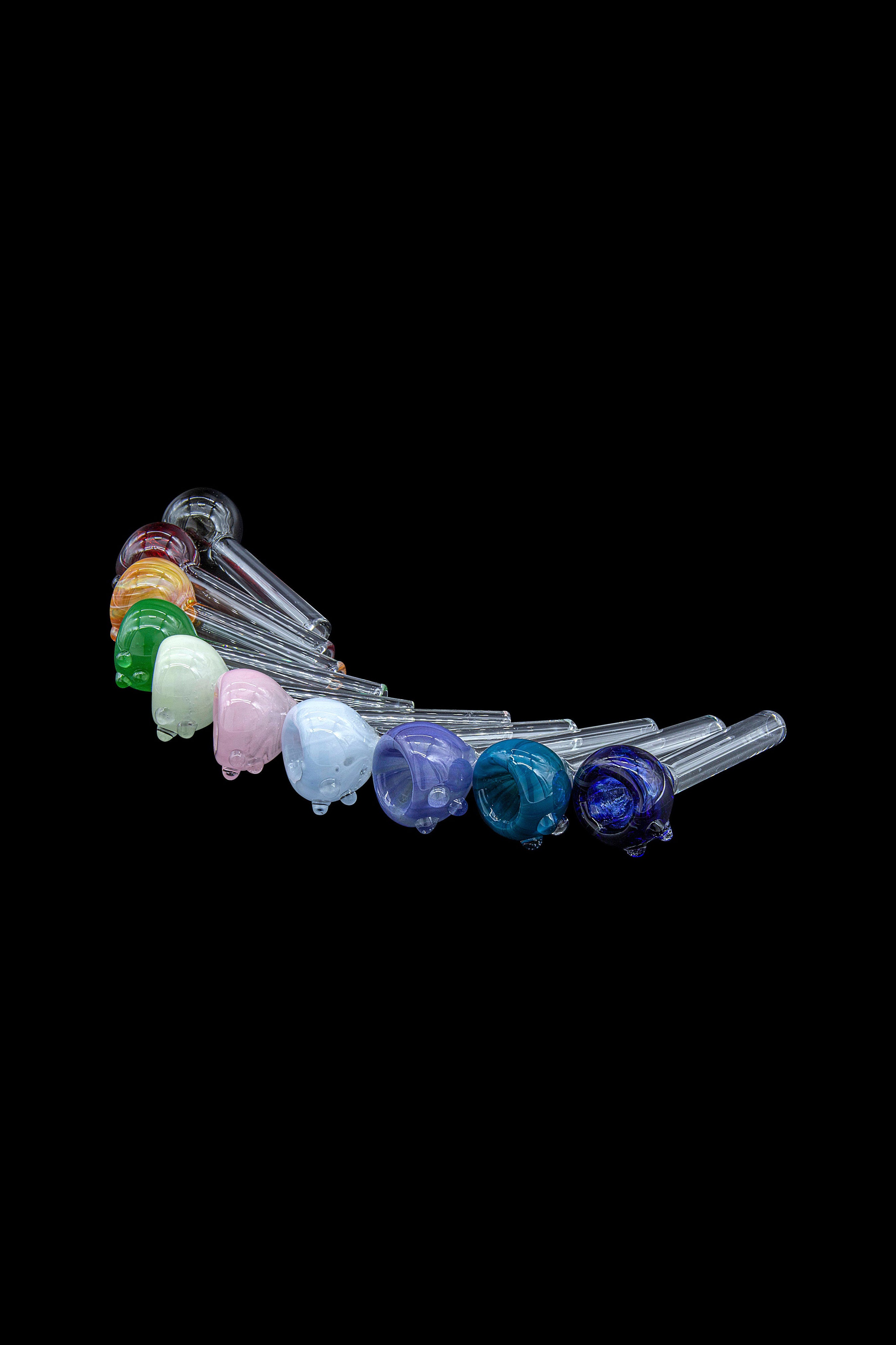 A row of colorful glass smoking pipes against a black background.