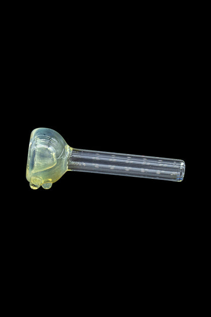 Yellow glass pipe for smoking cannabis, isolated on a black background.