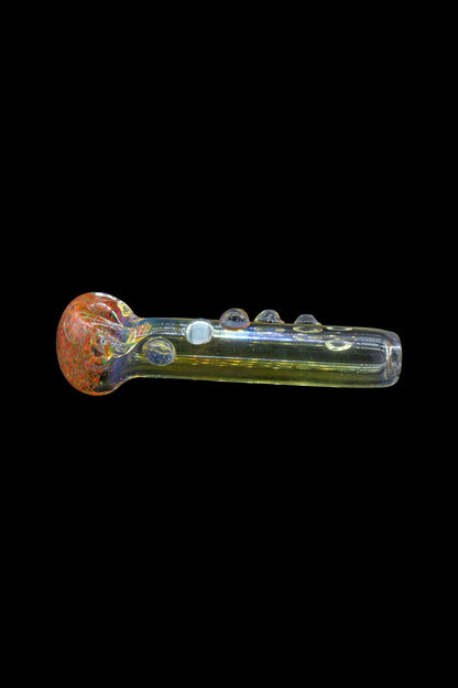 Hand pipe with iridescent green glass and a red and orange marbled bowl, isolated on a black background.