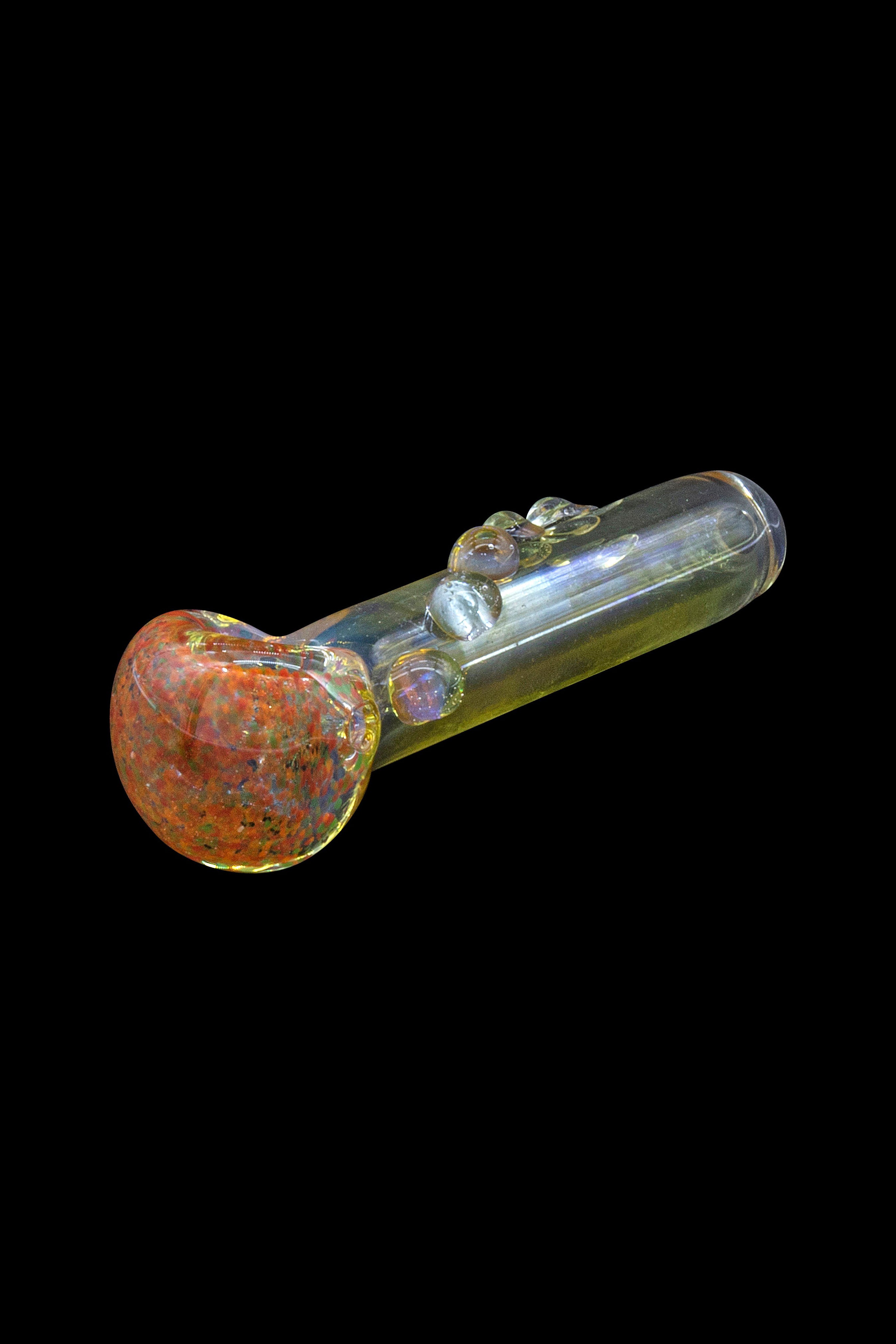 Glass pipe with red and orange speckled bowl against a black background.