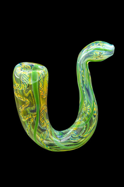 Green and yellow glass cannabis oil rig on black background.