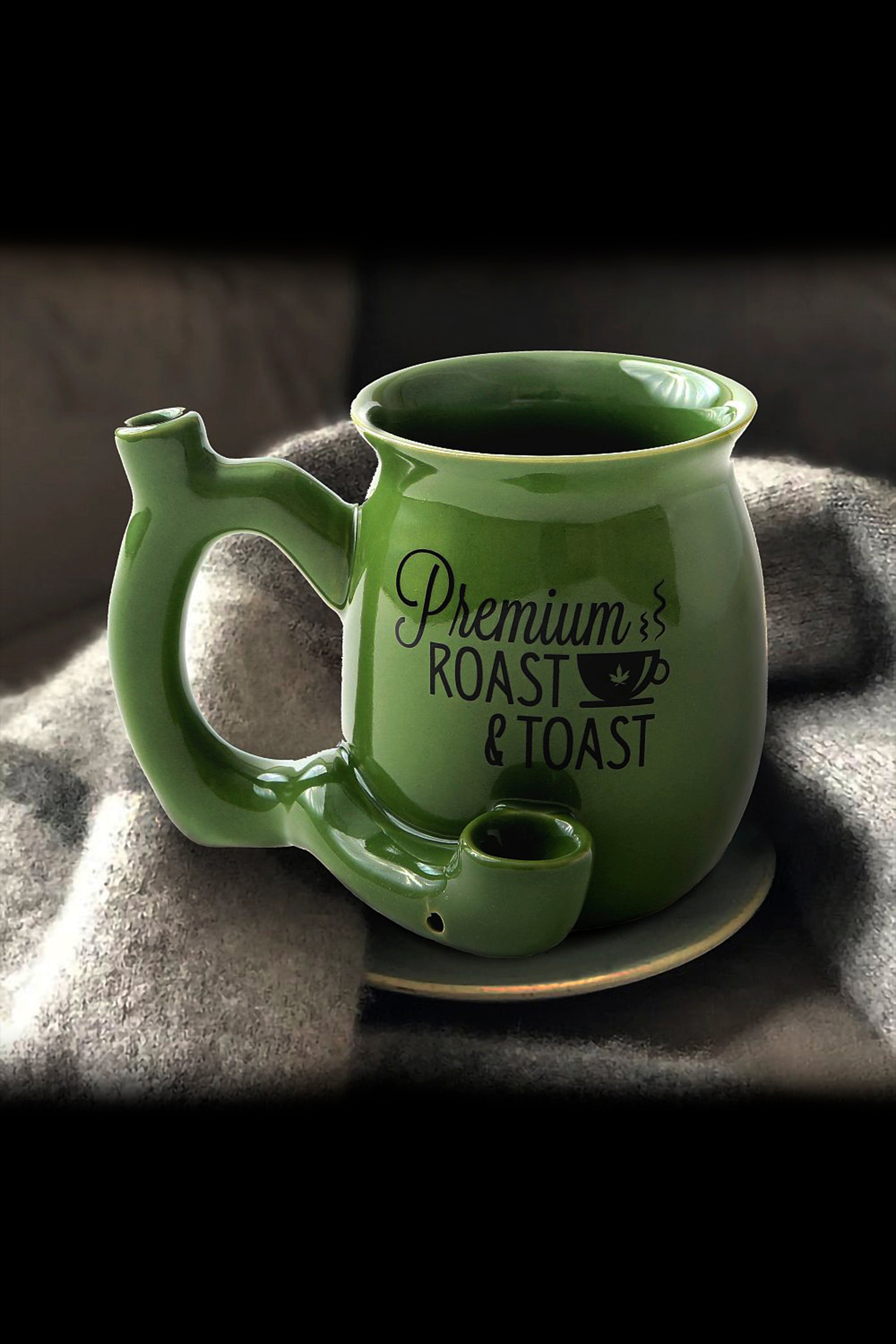 Green ceramic mug with built-in pipe and text “Premium Roast” on a textured surface.