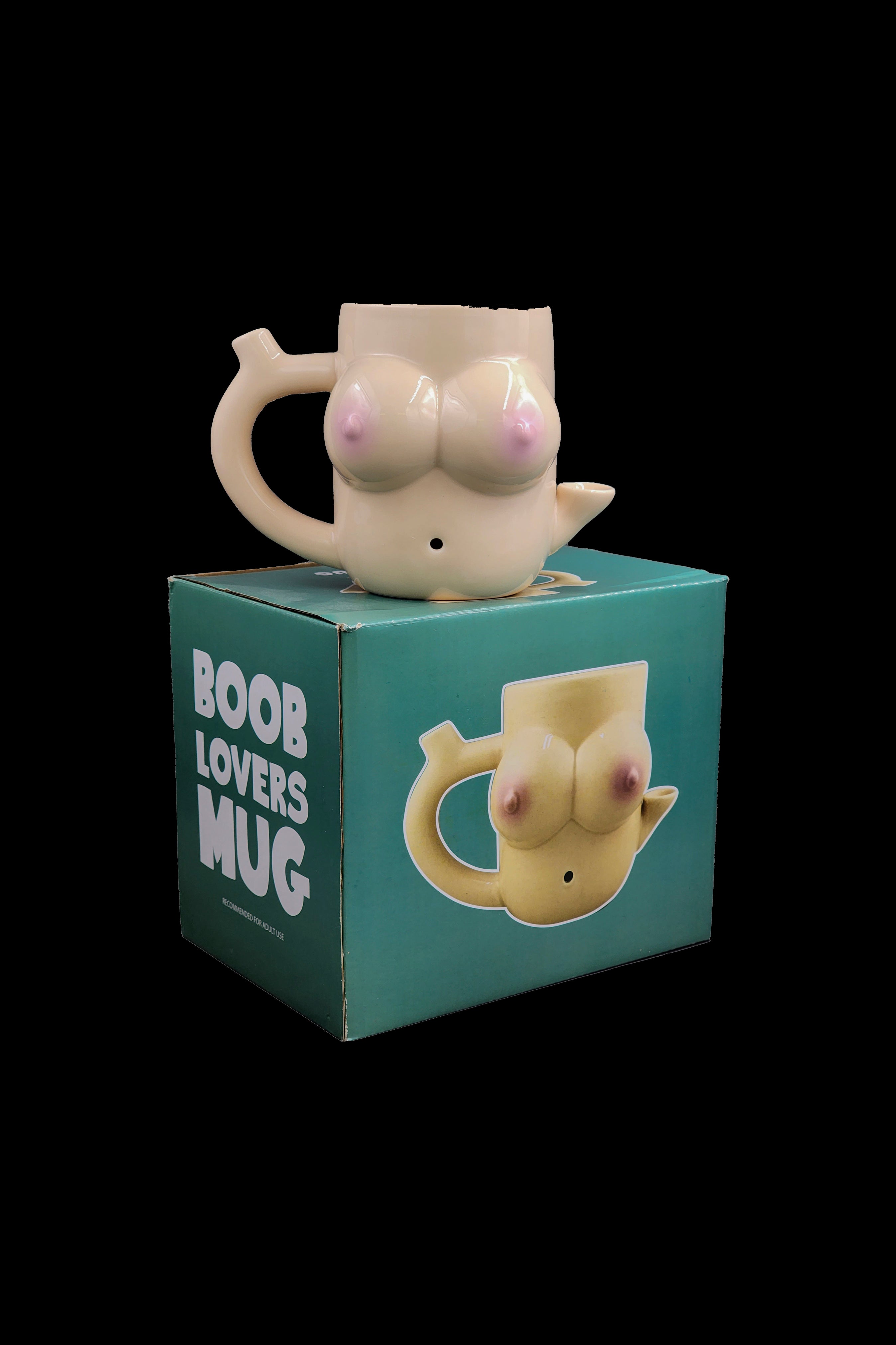 A ceramic mug shaped like a pair of breasts sits atop its retail box, which features a similar illustration and the text "Boob Lovers Mug." 