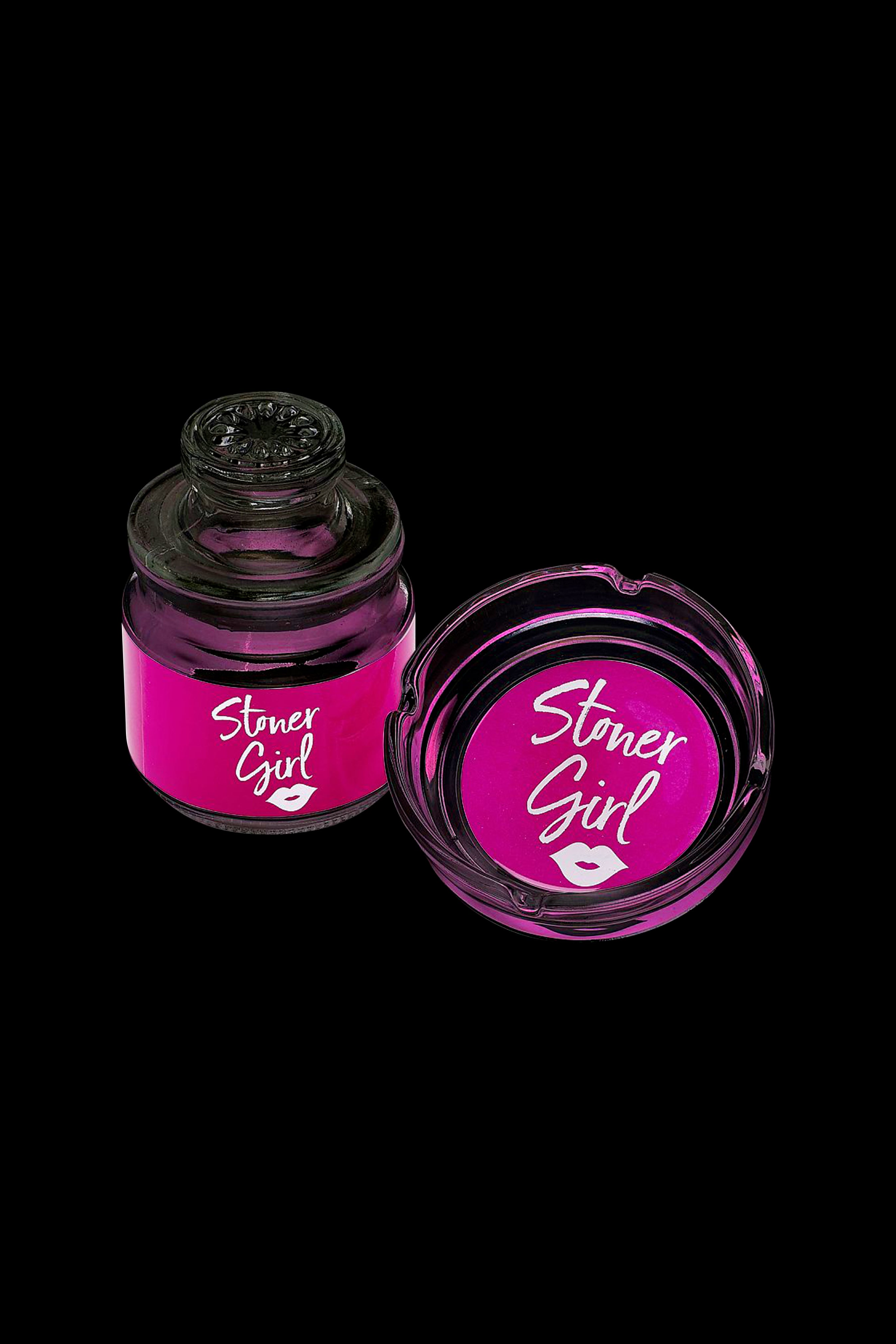 Two pink jars labeled “Stoner Girl” with a kiss imprint, likely containing cannabis concentrate or a similar product, against a black background.