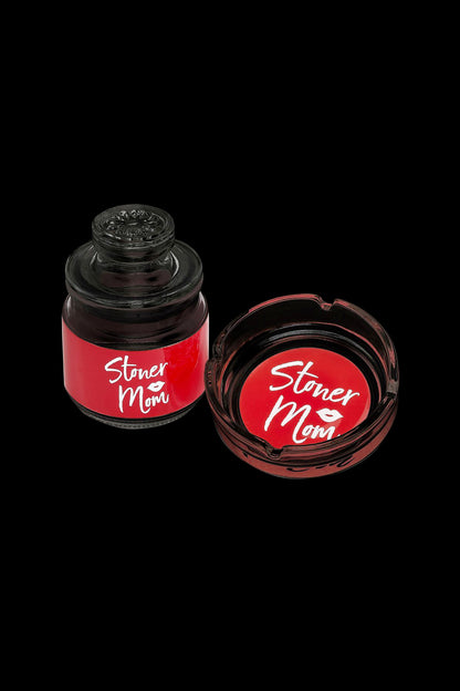 Two red jars labeled "Stoner Mom" with white script, likely containing cannabis concentrates or accessories, isolated on a black background.
