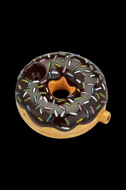 Chocolate donut-shaped glass pipe with colorful sprinkles, isolated on a black background."