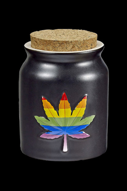 Black glass jar with a rainbow cannabis leaf emblem and cork lid.