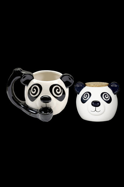 White ceramic panda-shaped mug with a built-in glass pipe, alongside a matching panda-shaped storage container with a cork lid, isolated on a black background.