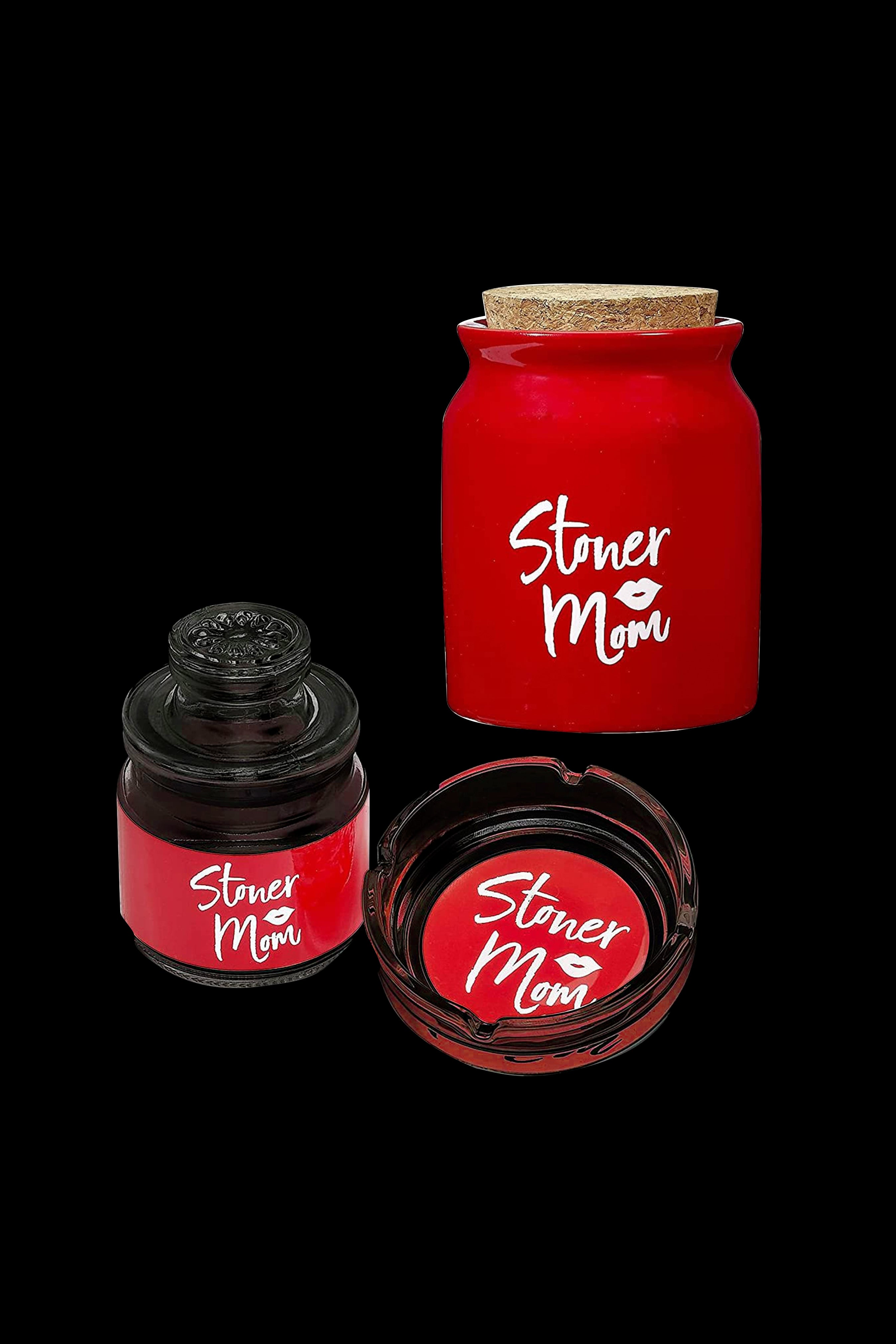 Red cannabis concentrate jars labeled “Stoner Mom” with dark, viscous oil visible inside, arranged on a black background.