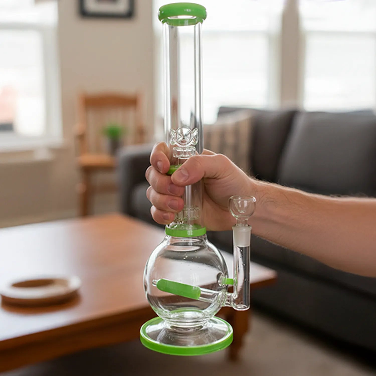 Handheld Smoke Cartel Inline Glass Ball with UFO & Circ Perc Bong - 16 in., shown upright with milky green accents in a living room.