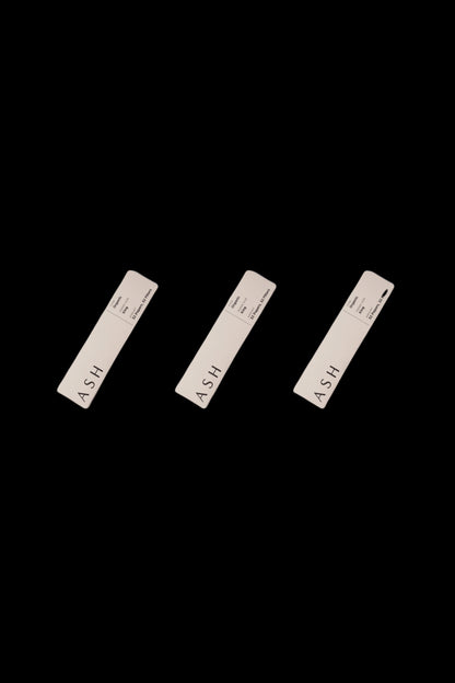 Three minimalist, rectangular cannabis pre-roll packs labeled "ASH" against a black background.