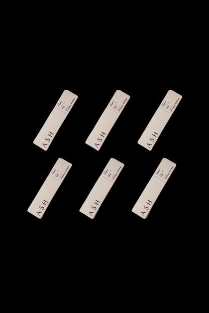 Six white cannabis ashtrays with the word "ASH" printed on a black background.
