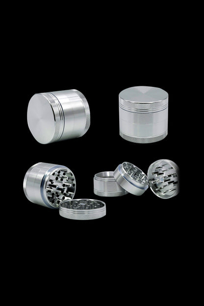 A disassembled view of the Cloud 8 Aluminum 4 Piece Grinder, showing its four separate metallic components against a dark background.