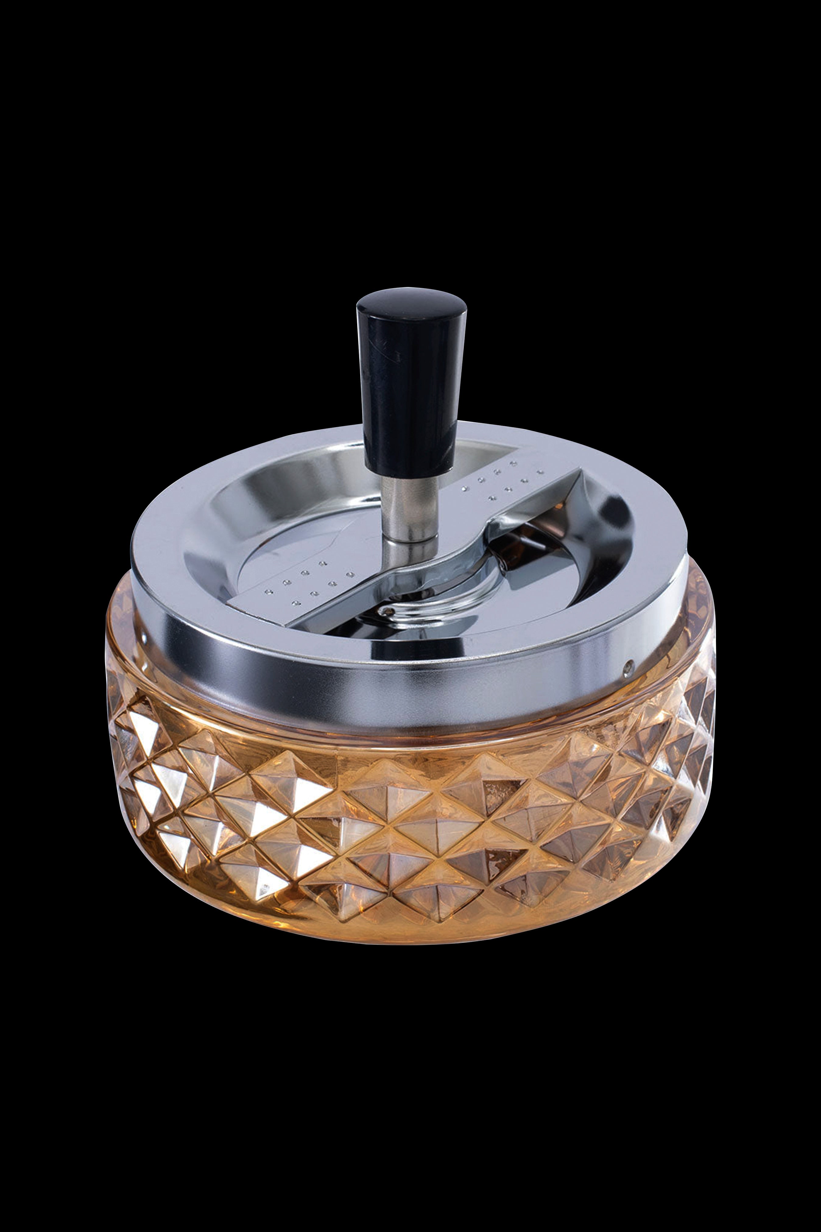 A metallic and glass grinder for cannabis, featuring a faceted amber-colored base and a silver grinding mechanism with a black knob.