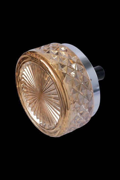 Golden glass cannabis grinder with metallic base, isolated on black.