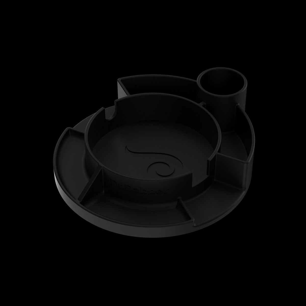 Angled close-up of the matte black Switch™ Silicone Base showing its circular compartments and subtle top-down shadows