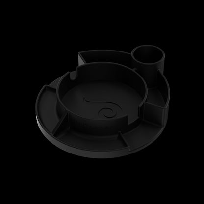 Angled close-up of the matte black Switch™ Silicone Base showing its circular compartments and subtle top-down shadows
