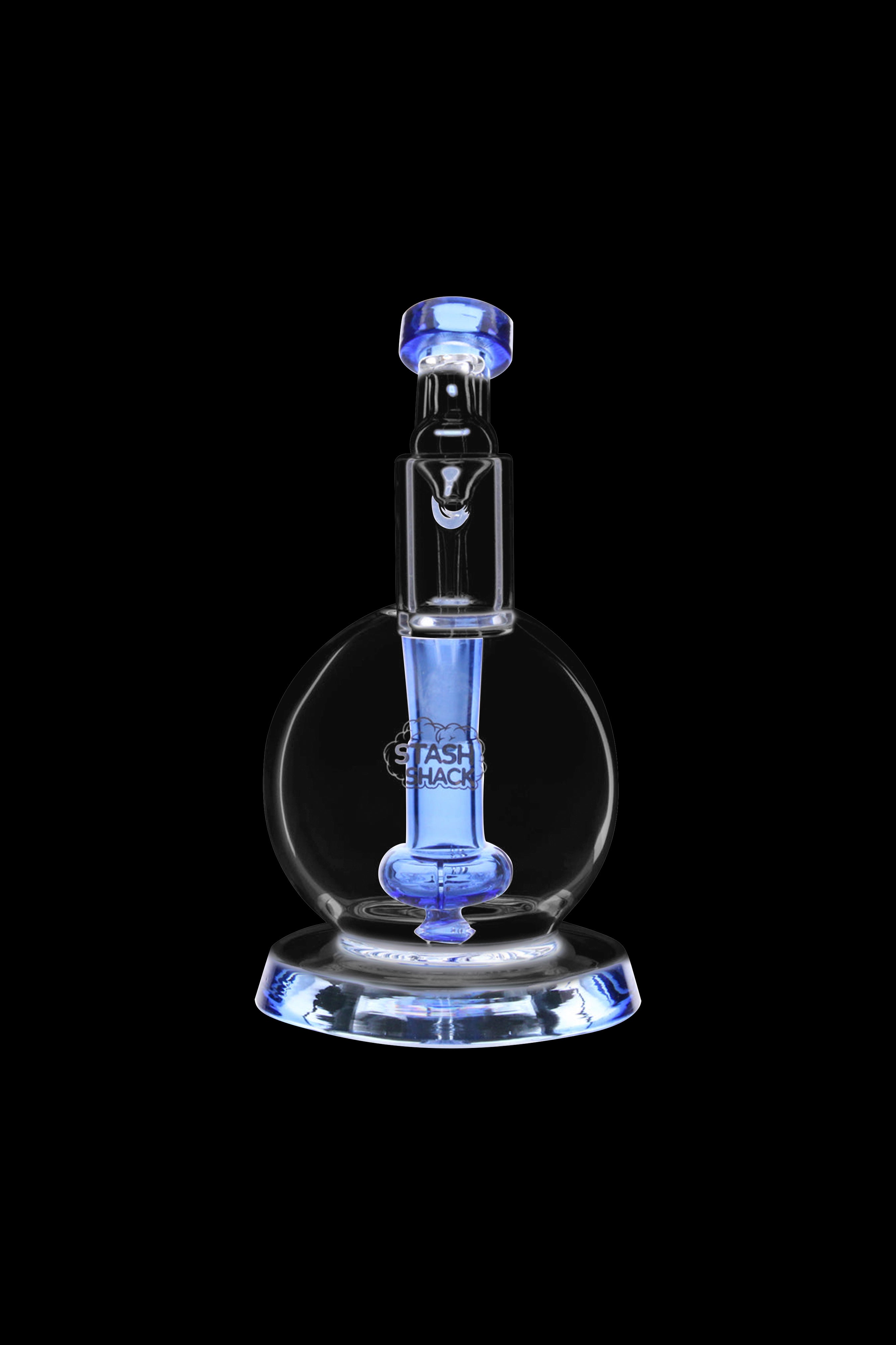 Blue glass dab rig with intricate design, illuminated against a black background.