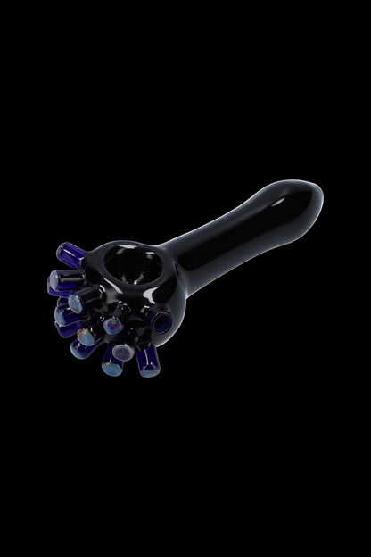Black glass pipe with colorful glass accents, isolated on a black background.