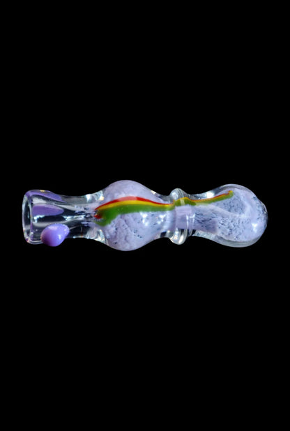 Side view of the Smoke Cartel Frit Rasta One Hitter - 3 in. showing a clear glass, bumpy 3-inch pipe with a central red-yellow-green rasta stripe against a black background