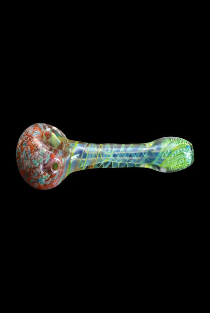 Horizontal close-up of the Smoke Cartel Twisting Frit Spoon Pipe - 3 in. showing a red-speckled bowl and iridescent twisted green neck against a black background