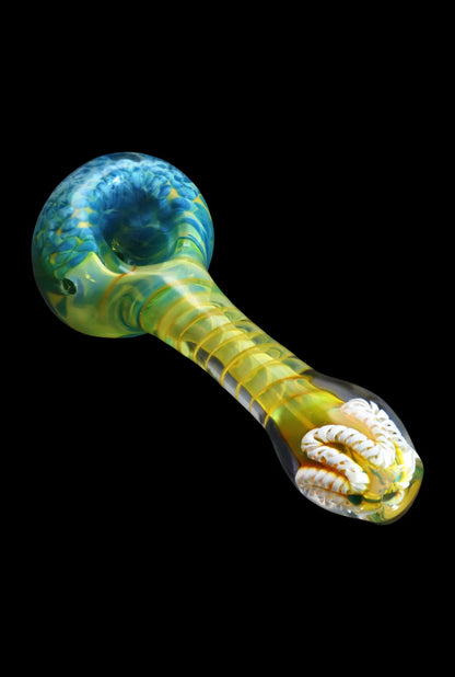 Angled close-up of the Smoke Cartel Twisting Frit Spoon Pipe - 3 in., showing a green and blue swirled bowl and a yellow-green twisted stem against a black background