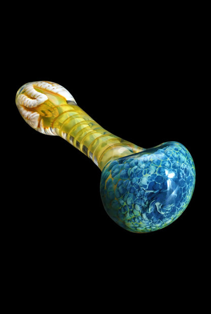 Angled close-up of the Smoke Cartel Twisting Frit Spoon Pipe - 3 in., showing a blue frit bowl and yellow swirled stem on black.